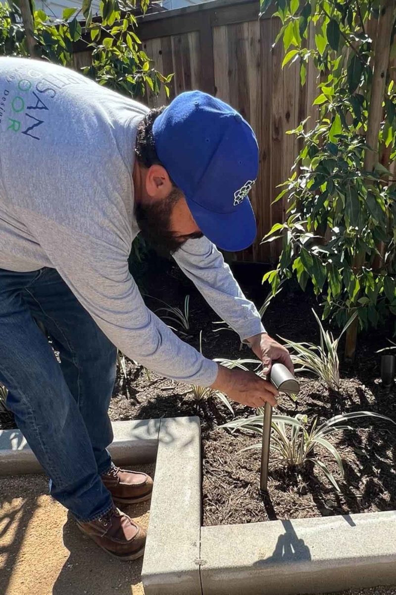 Landscaper installing a light in a garden