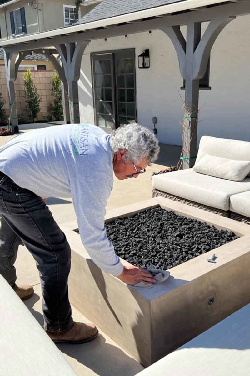 Landscaper wiping down a fire pit