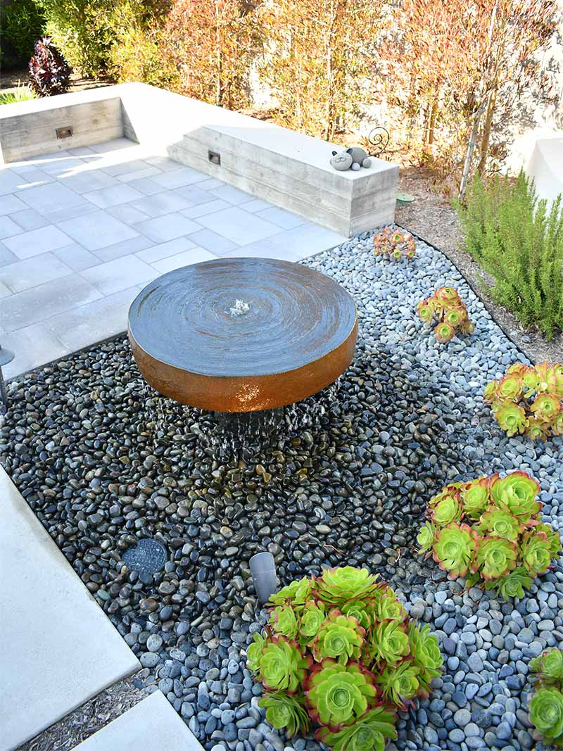 Water fountain with pebbles and plants