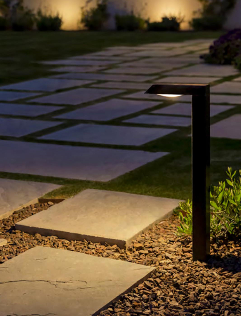 A cobblestone pathway with a light shining on it