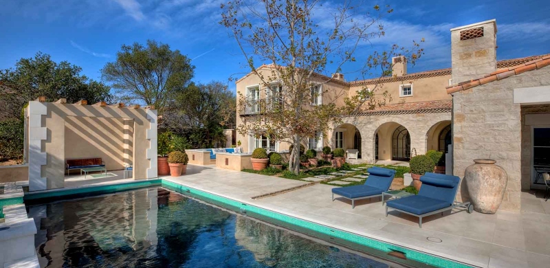 An image of a backyard with a pool and stone landscaping.